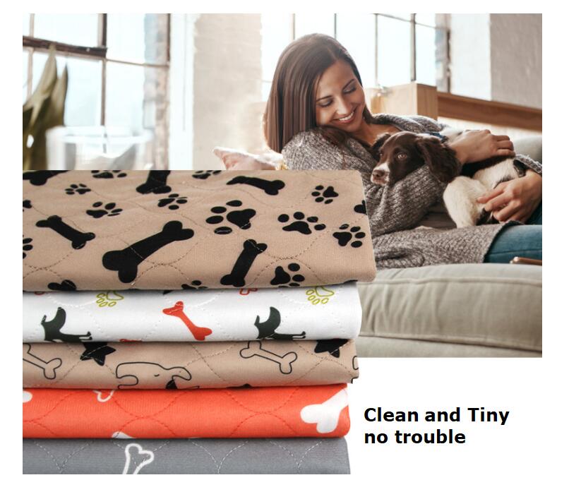 Stack of dog blankets with paw and bone patterns next to a woman holding a dog.