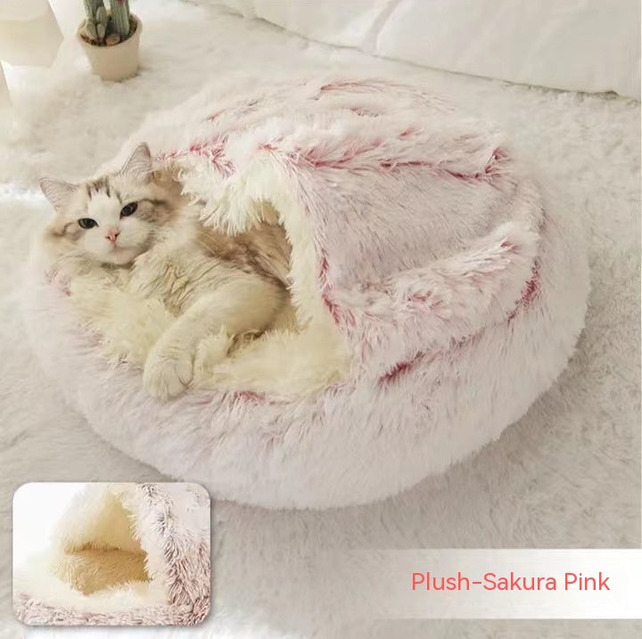 Cat lounging in a plush Sakura Pink pet bed on a white surface.