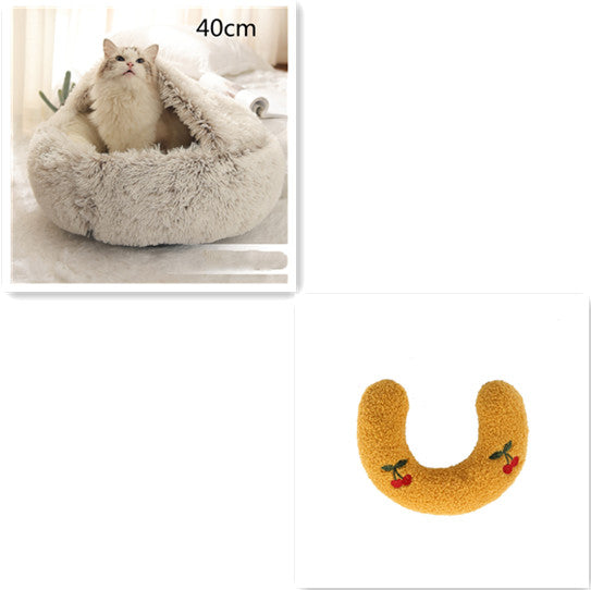 Cat lying in a fluffy pet bed with a close-up of a yellow U-shaped toy with cherries on a white background.