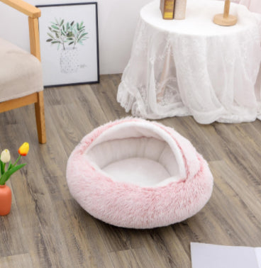 Pink pet bed on a wooden floor with a blurred background