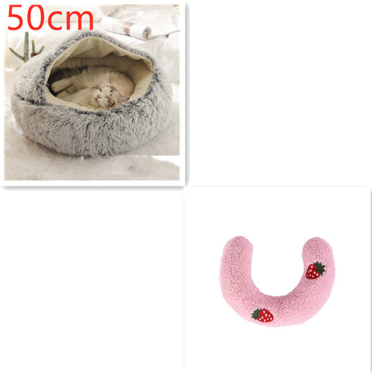 Cat bed with a cat inside and a pink U-shaped pillow with strawberry design on a white background.
