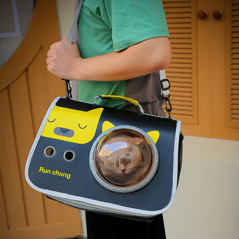 Person holding a pet carrier with a cat inside, featuring a cartoon cat design on a yellow background.