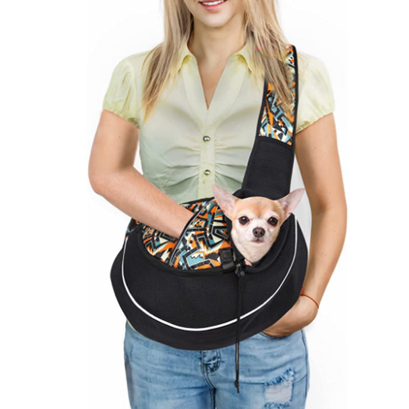 Person holding a black pet sling with a small dog inside, on a white background