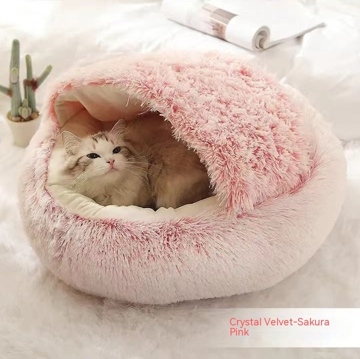 Cat lying in a fluffy pink pet bed on a light background