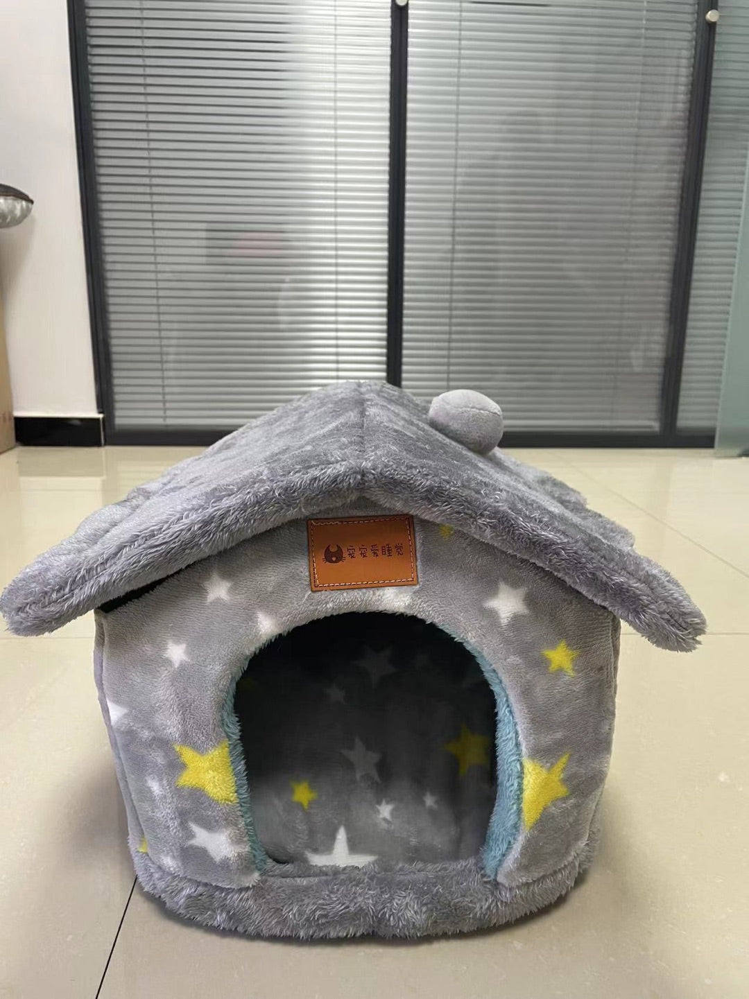 Gray pet bed with star patterns on a tiled floor